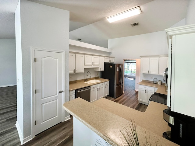 kitchen featuring stainless steel appliances, dark wood-type flooring, and white cabinets