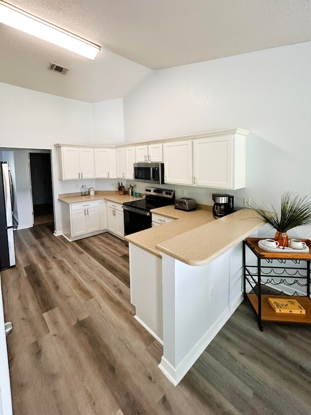 kitchen featuring white cabinets, kitchen peninsula, light hardwood / wood-style flooring, and stainless steel appliances