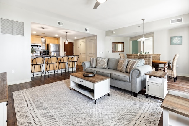 living room with ceiling fan and dark hardwood / wood-style floors