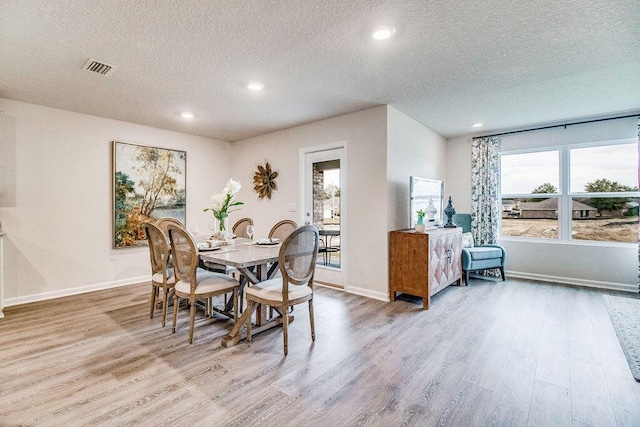 dining area featuring a healthy amount of sunlight, light wood-style flooring, and baseboards