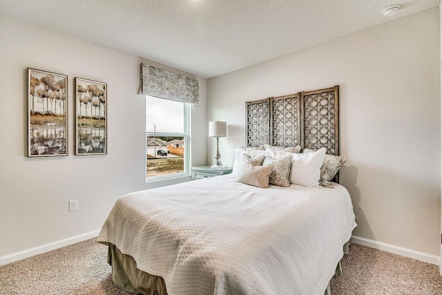 carpeted bedroom featuring baseboards and a textured ceiling