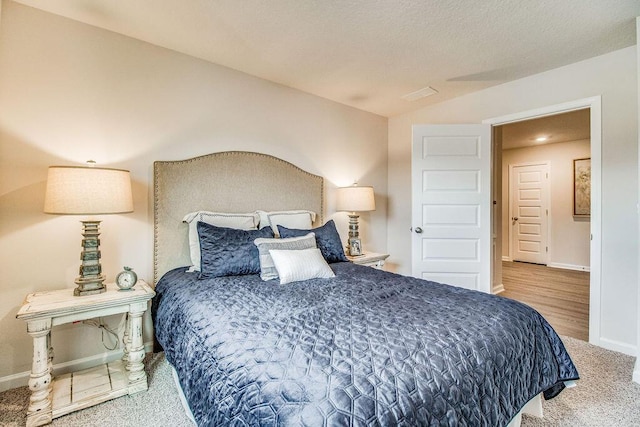 carpeted bedroom featuring vaulted ceiling and baseboards