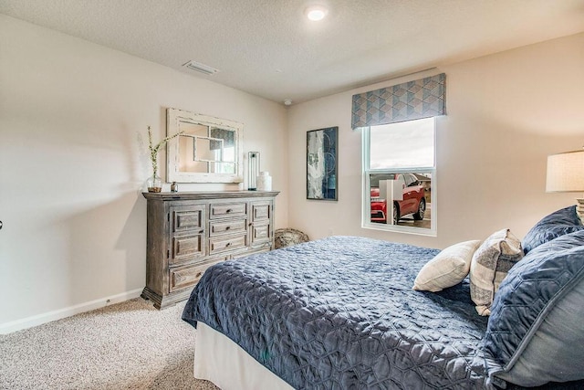 bedroom featuring light carpet, a textured ceiling, baseboards, and multiple windows