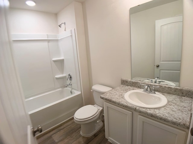 bathroom featuring toilet, vanity, wood finished floors, and washtub / shower combination