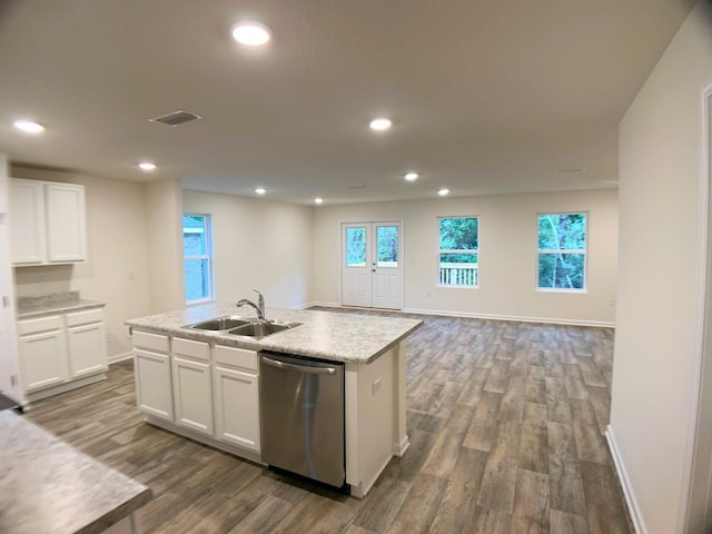 kitchen featuring a sink, white cabinets, open floor plan, dishwasher, and a center island with sink