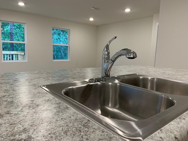 interior details featuring visible vents, light countertops, a sink, and recessed lighting