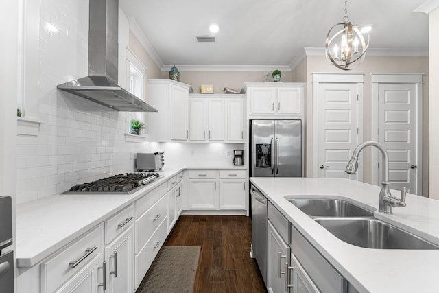 kitchen featuring stainless steel appliances, a sink, light countertops, wall chimney exhaust hood, and crown molding