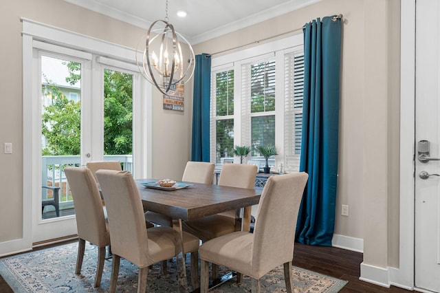 dining space featuring dark wood-style floors, plenty of natural light, a chandelier, and crown molding