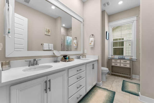 bathroom featuring visible vents, a sink, a shower with door, and toilet