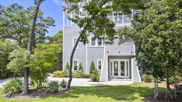 back of house with french doors and a yard