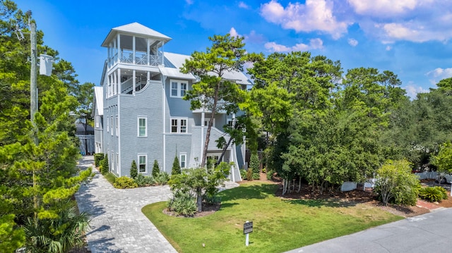 exterior space with a balcony and a front lawn