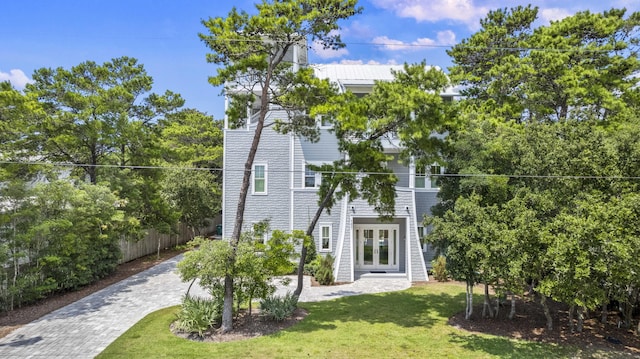 exterior space featuring a lawn, fence, and french doors
