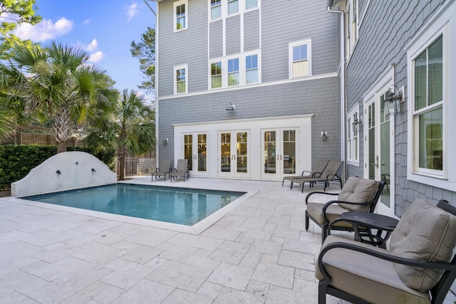 view of pool with fence, a patio area, a fenced in pool, and french doors