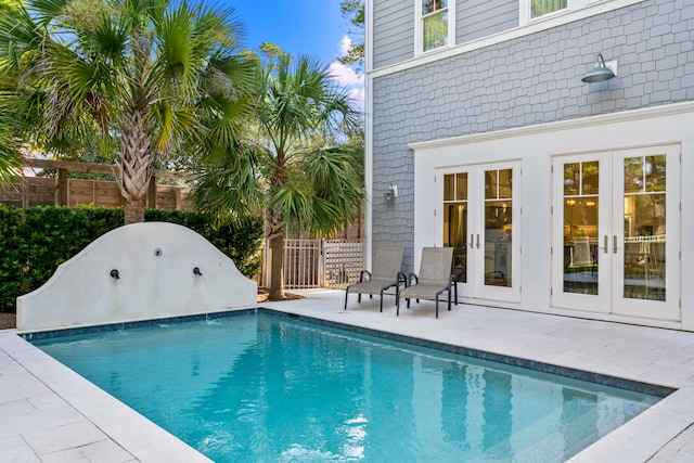 view of swimming pool featuring a patio area and french doors