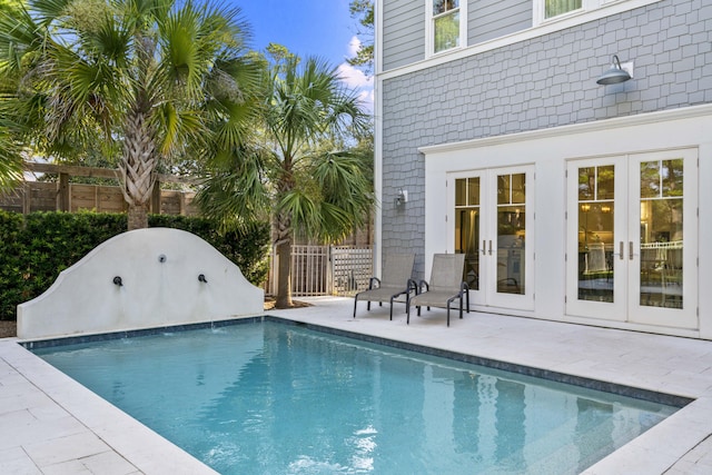 view of pool with fence, a fenced in pool, french doors, and a patio