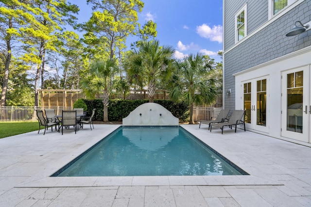 view of pool with a fenced backyard, a patio area, a fenced in pool, and french doors