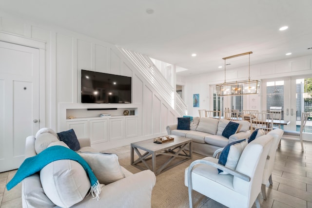 living room featuring a notable chandelier and french doors