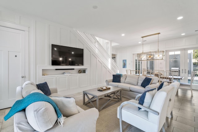 living area with a decorative wall, stairs, light wood-style floors, and recessed lighting