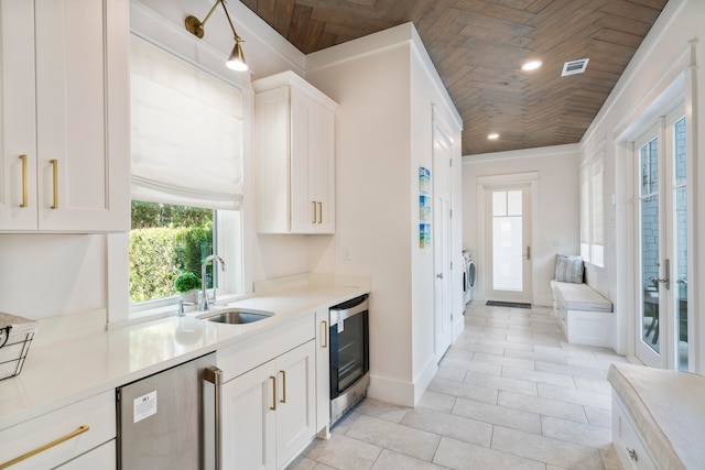 kitchen with white cabinetry, wine cooler, wood ceiling, and sink