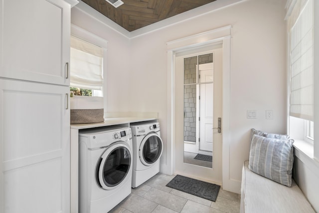 washroom featuring visible vents, washing machine and clothes dryer, light tile patterned floors, and laundry area