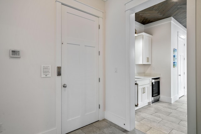 interior space with baseboards, beverage cooler, and light tile patterned floors