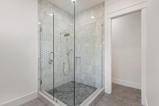 full bathroom featuring baseboards and a stall shower
