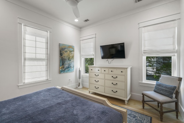 bedroom featuring wood finished floors, visible vents, baseboards, and ceiling fan