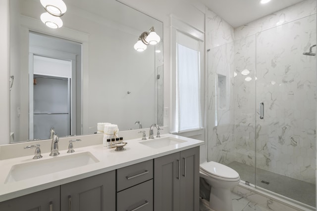 full bathroom featuring marble finish floor, toilet, a sink, and a marble finish shower