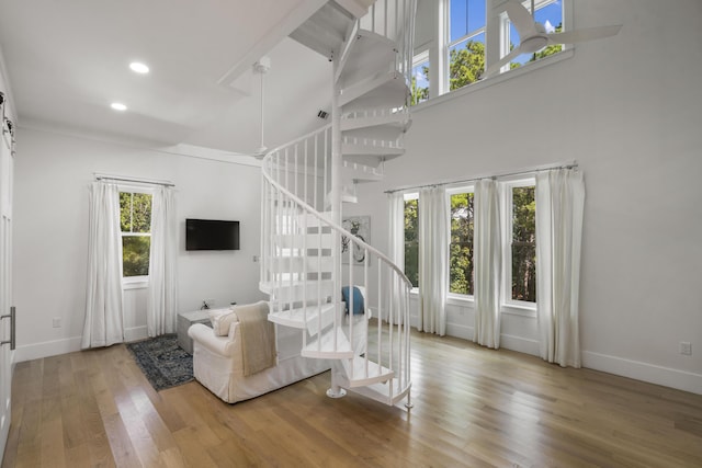 living room with baseboards, wood finished floors, stairs, and recessed lighting