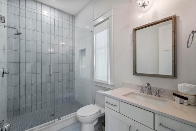 bathroom with tile patterned floors, a shower with door, vanity, and toilet