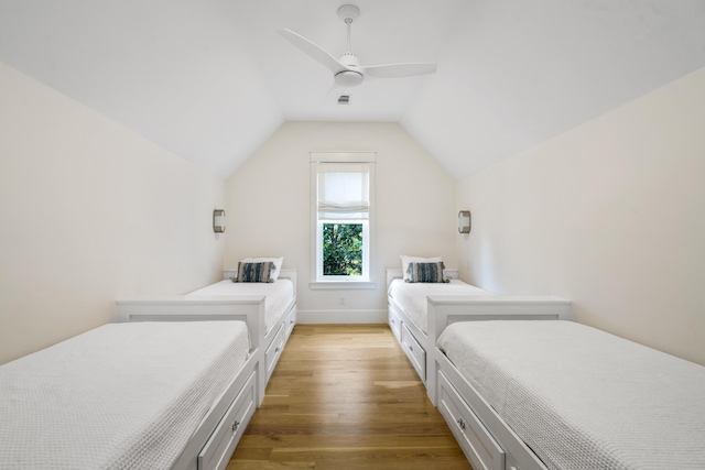 bedroom featuring ceiling fan, lofted ceiling, baseboards, and light wood-type flooring