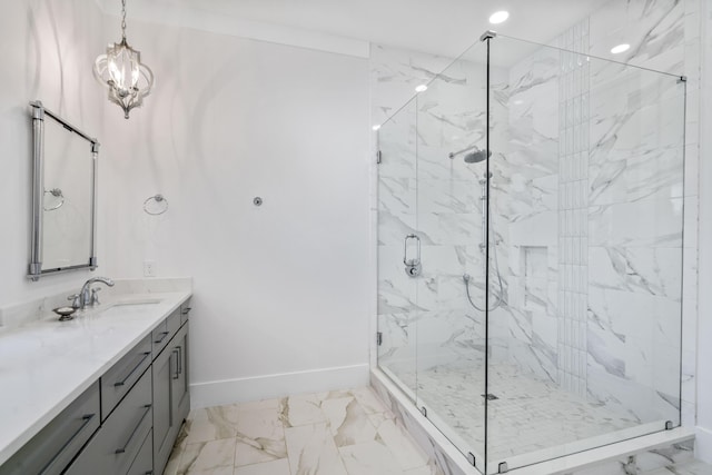 bathroom with a marble finish shower, vanity, marble finish floor, an inviting chandelier, and baseboards
