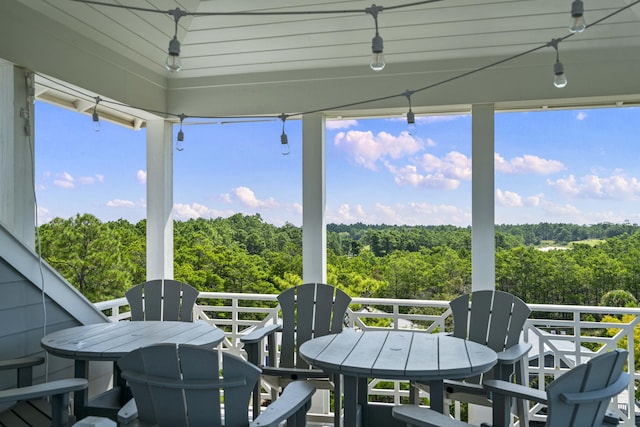 balcony with a forest view and outdoor dining area