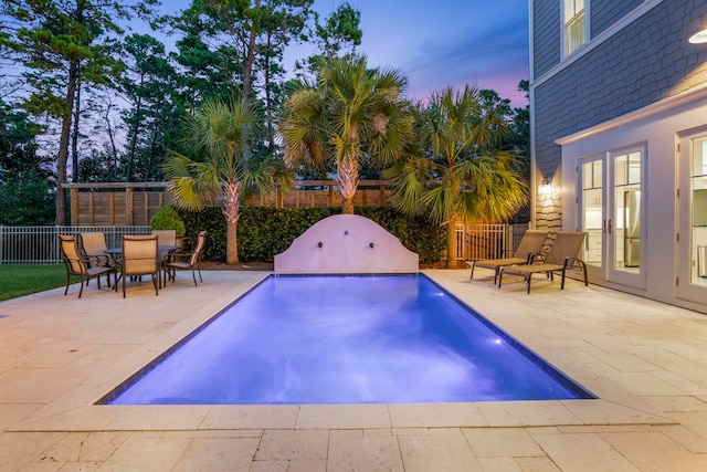 pool at dusk with a patio