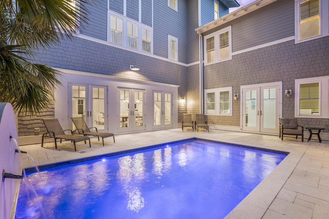 outdoor pool with french doors and a patio