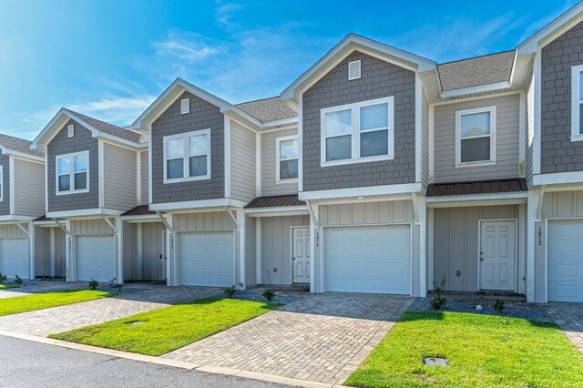 townhome / multi-family property with a garage and a front yard