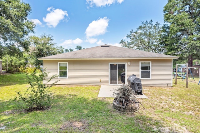 back of property with a patio, a playground, and a lawn