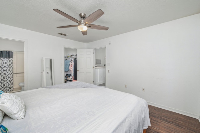 bedroom with a walk in closet, a closet, ceiling fan, hardwood / wood-style flooring, and ensuite bathroom