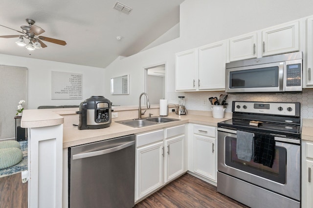 kitchen featuring appliances with stainless steel finishes, dark hardwood / wood-style floors, ceiling fan, kitchen peninsula, and lofted ceiling