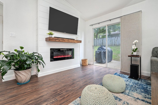 living room with a fireplace, hardwood / wood-style flooring, and lofted ceiling