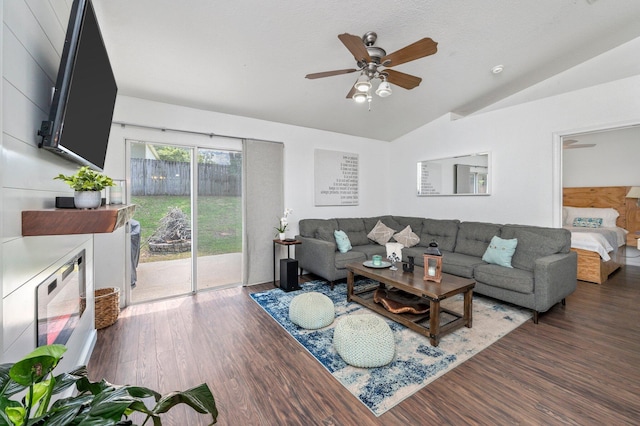 living room featuring ceiling fan, dark wood-type flooring, and lofted ceiling