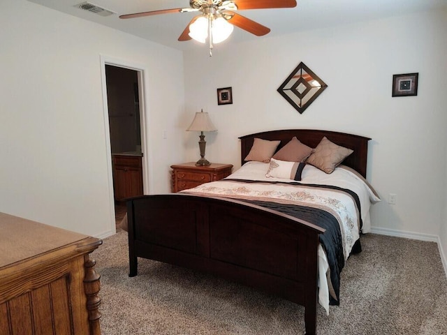 bedroom with light carpet, a ceiling fan, connected bathroom, and baseboards