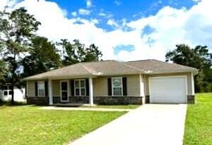view of front of house with driveway, a garage, and a front yard