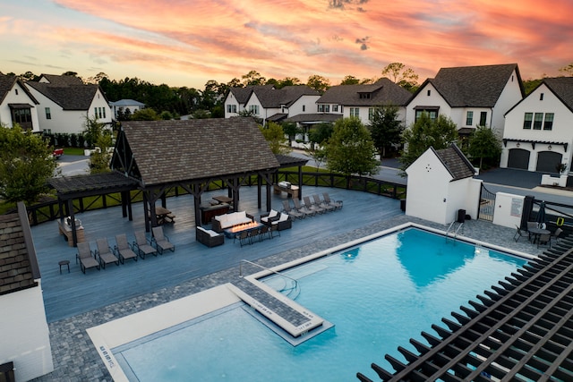 pool at dusk with a gazebo and a patio