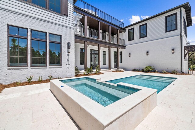 view of swimming pool featuring an in ground hot tub and a patio