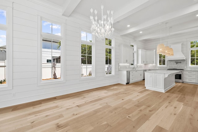 interior space with light hardwood / wood-style flooring, a healthy amount of sunlight, and beam ceiling