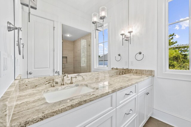 bathroom featuring a shower with door, vanity, and tile patterned floors