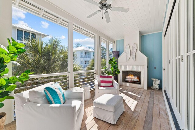 sunroom with a fireplace and ceiling fan