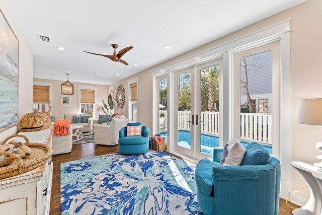 living room with ceiling fan, french doors, and dark hardwood / wood-style flooring