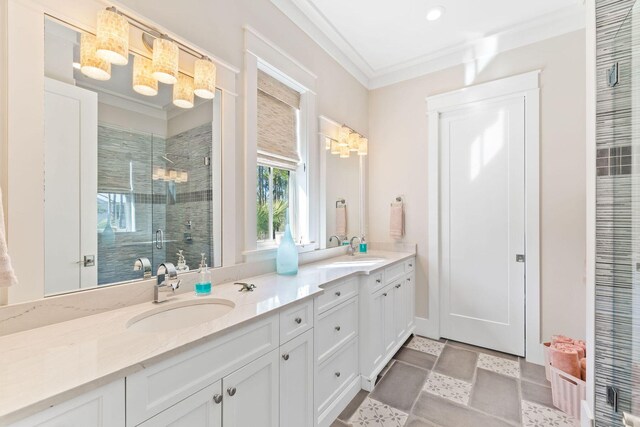 bathroom with tile patterned flooring, a shower with door, crown molding, and vanity